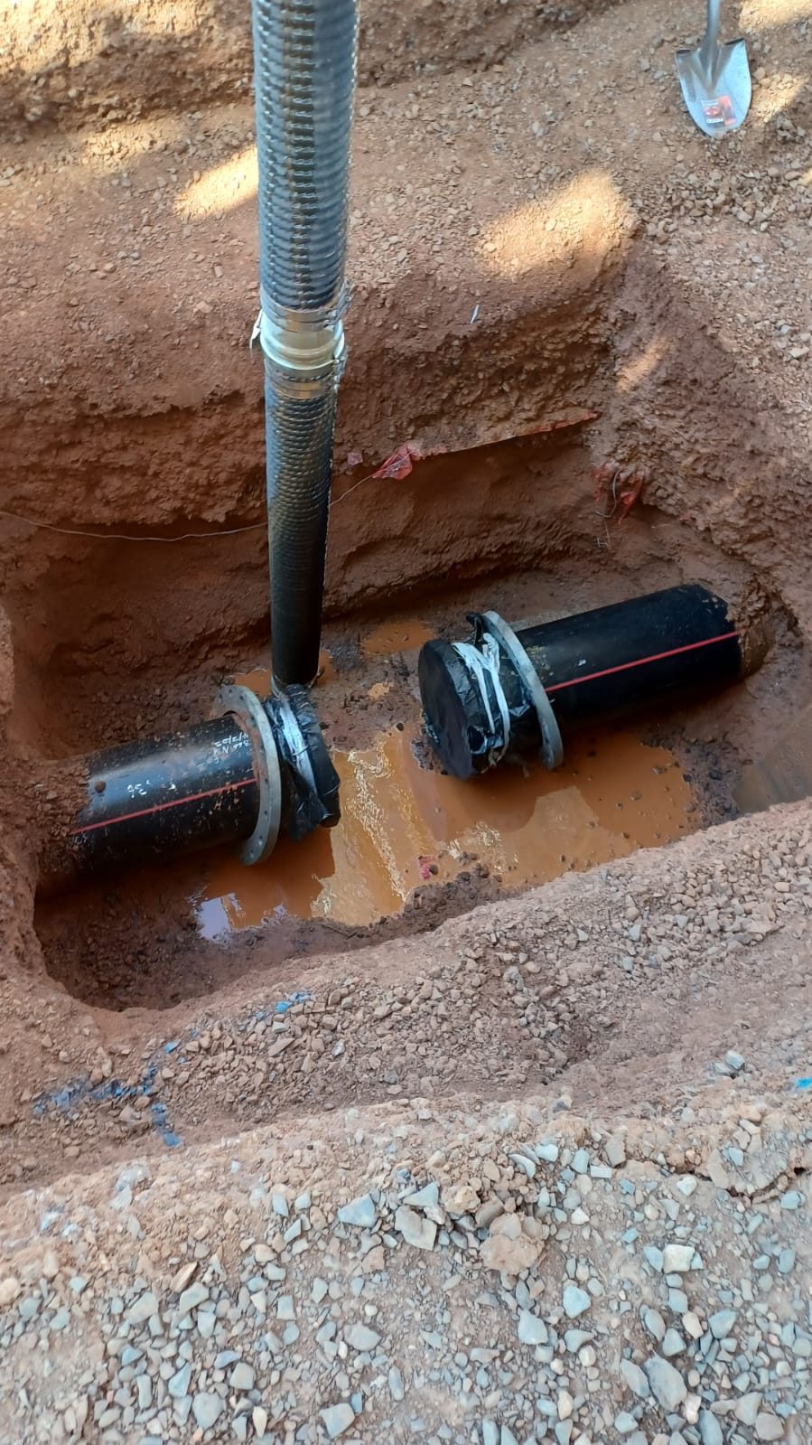 Live HDPE services exposed cleanly in a vacuum-excavated pothole
