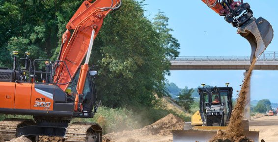 GPS-guided excavator and dozer working in cut